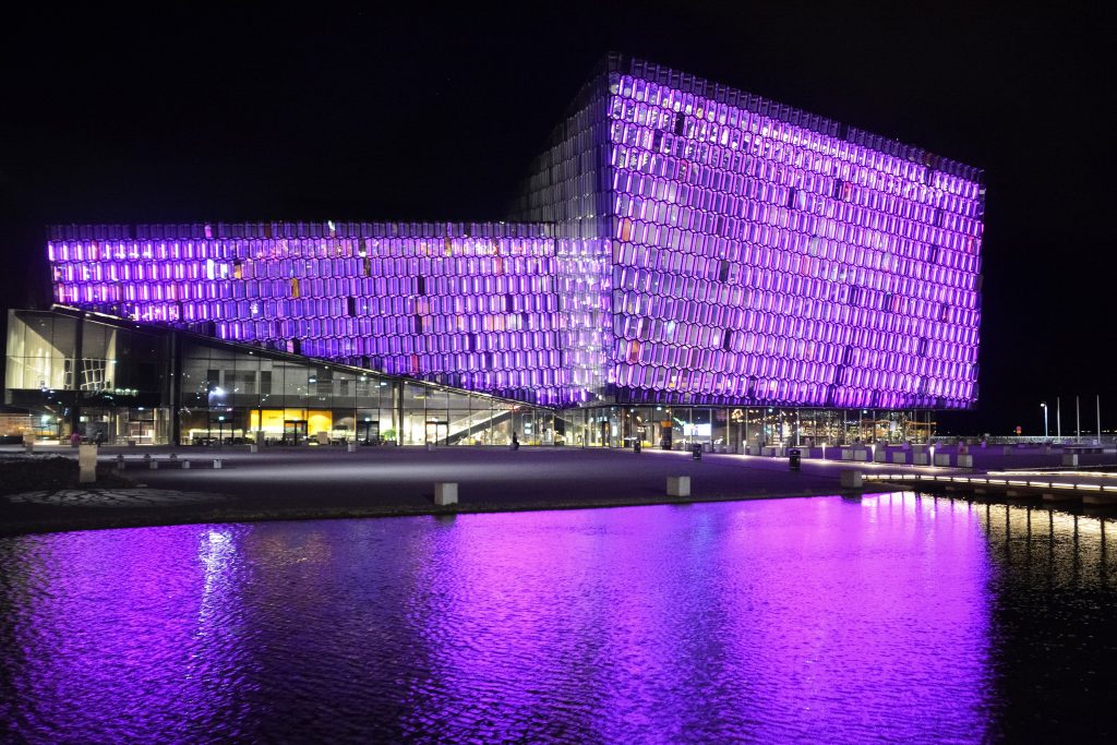 the Harpa Concert Hall in Reykjavík at night, lit up in purple
