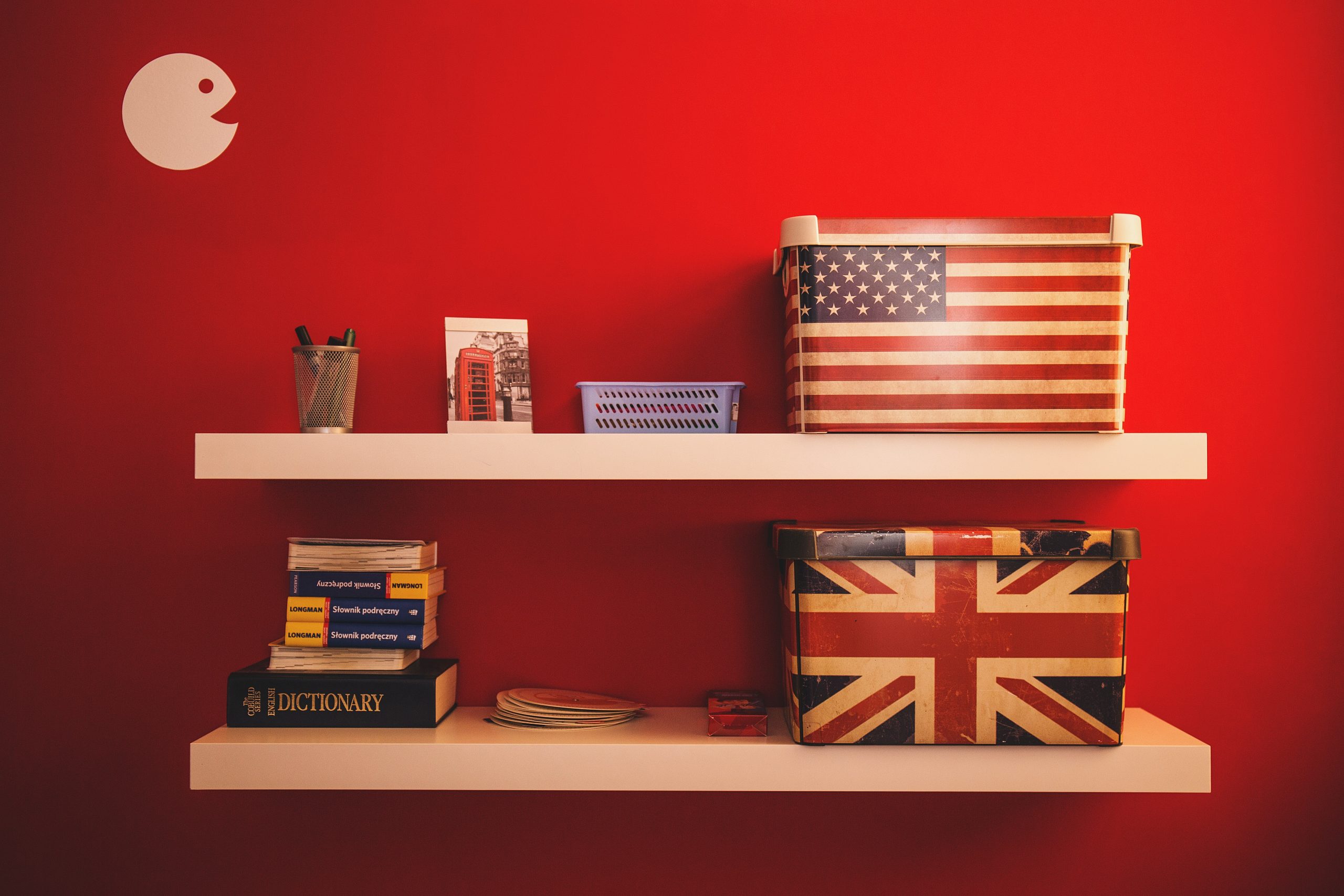 floating shelves on a wall with a number of items on them including boxes decorated with the US and UK flags